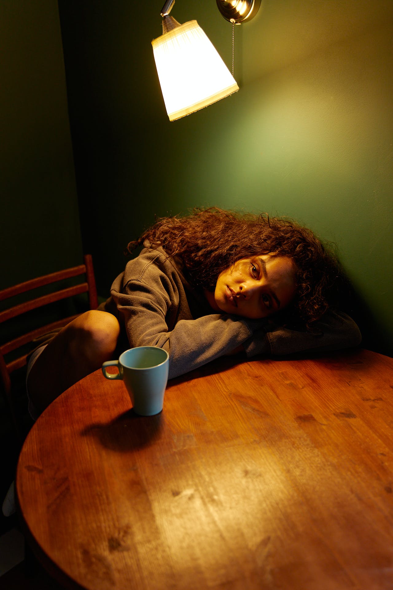Photo by Darina Belonogova: https://www.pexels.com/photo/a-woman-in-gray-sweater-lying-her-head-on-a-wooden-table-7208998/